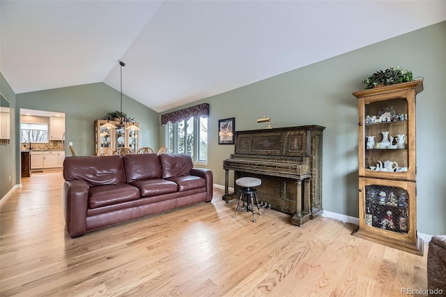 2522 W Dry Creek Ct, Littleton, CO 80120 - living area featuring vaulted ceiling, light wood-type flooring, healthy amount of natural light, and baseboards