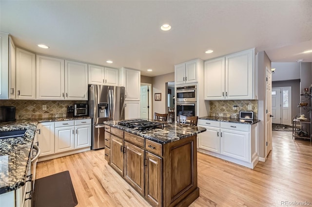 2522 W Dry Creek Ct, Littleton, CO 80120 - kitchen featuring stainless steel appliances, light wood-style floors, white cabinets, dark stone counters, and recessed lighting