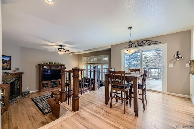2522 W Dry Creek Ct, Littleton, CO 80120 - dining area with light wood-type flooring, plenty of natural light, baseboards, and a high end fireplace