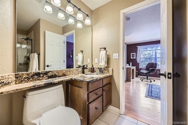 2522 W Dry Creek Ct, Littleton, CO 80120 - bathroom featuring tile patterned floors, baseboards, vanity, toilet, and a textured wall