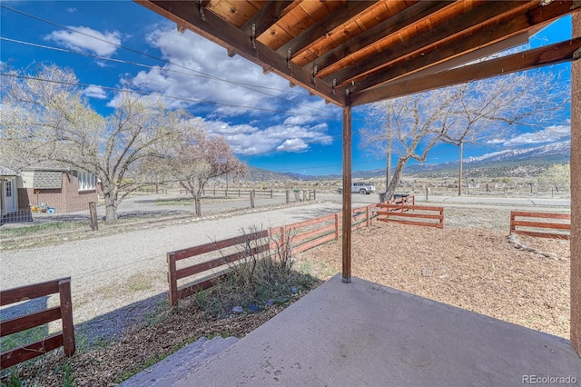 view of patio / terrace with a rural view and fence