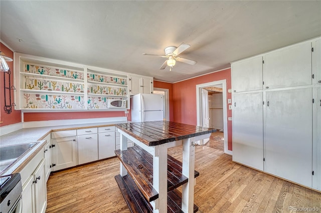 kitchen with a ceiling fan, white appliances, white cabinetry, open shelves, and light wood-type flooring