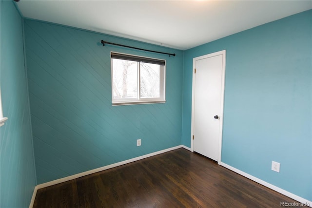 empty room with dark hardwood / wood-style flooring