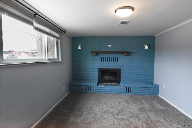 unfurnished living room featuring ornamental molding, a brick fireplace, and carpet