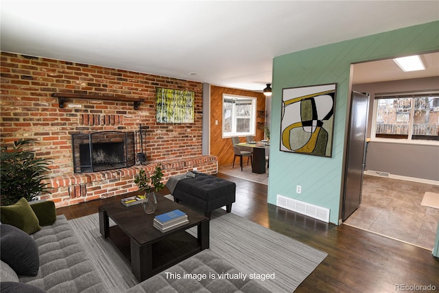 5063 W 61st Ave, Arvada, CO 80003 - living area with wood walls, plenty of natural light, a brick fireplace, wood finished floors, and baseboards
