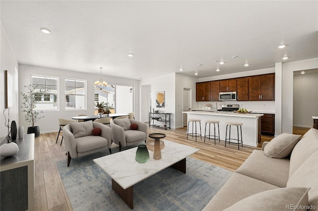 3401 N Denali St, Aurora, CO 80019 - living area with a chandelier, recessed lighting, light wood-style floors, and baseboards