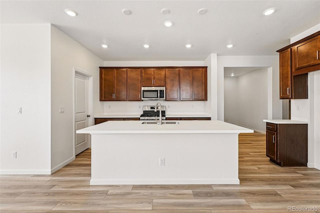 3401 N Denali St, Aurora, CO 80019 - kitchen featuring appliances with stainless steel finishes, a sink, a center island with sink, light countertops, and recessed lighting
