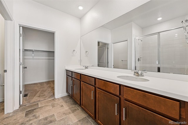 3401 N Denali St, Aurora, CO 80019 - bathroom with a spacious closet, double vanity, a shower stall, baseboards, and recessed lighting