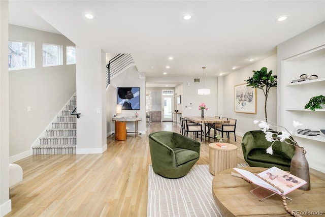 living room featuring recessed lighting, stairs, baseboards, and wood finished floors