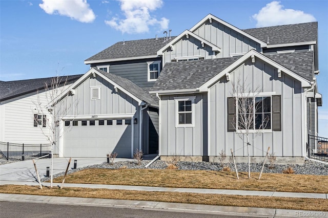 view of front of house with a garage, fence, driveway, roof with shingles, and board and batten siding