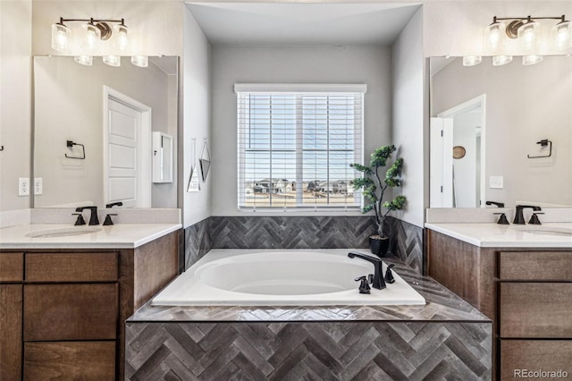 bathroom featuring two vanities, a sink, and a bath