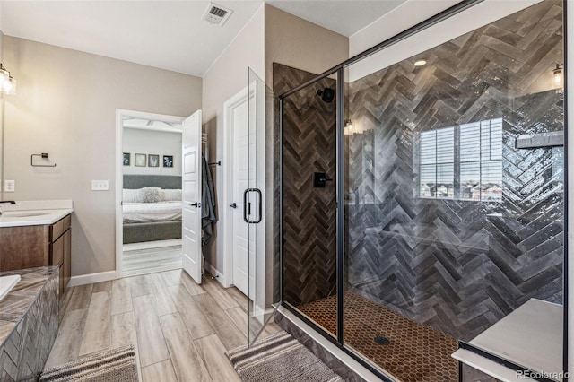 bathroom with a stall shower, vanity, visible vents, and ensuite bathroom