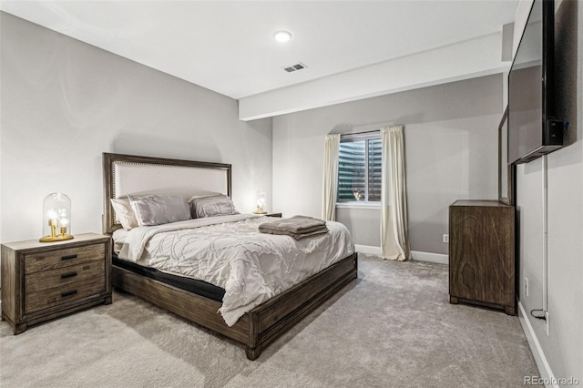 bedroom featuring baseboards, visible vents, and light colored carpet