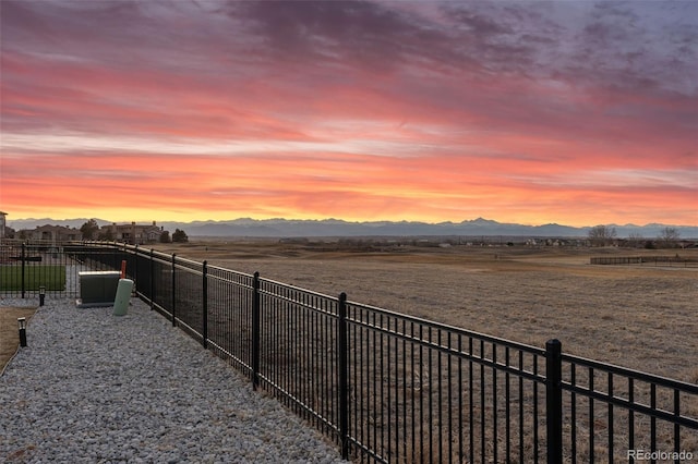 yard at dusk with fence and a mountain view