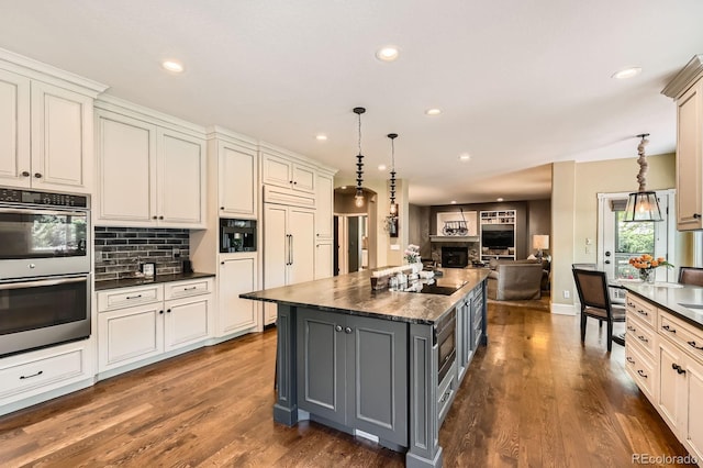 14118 Whitney Cir, Broomfield, CO 80023 - kitchen featuring double oven, gray cabinetry, recessed lighting, decorative backsplash, and a center island
