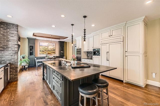 14118 Whitney Cir, Broomfield, CO 80023 - kitchen featuring dark countertops, paneled built in refrigerator, stainless steel double oven, black electric cooktop, and dark wood-style floors