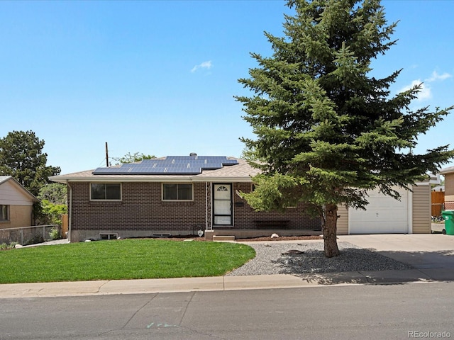 view of front facade featuring driveway, roof mounted solar panels, and brick siding