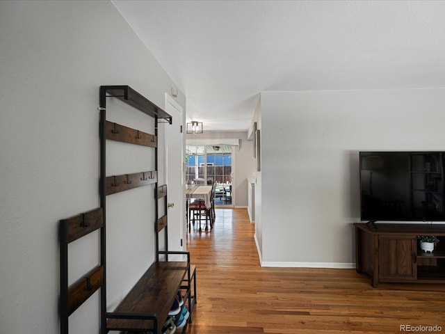 hall featuring wood finished floors and baseboards