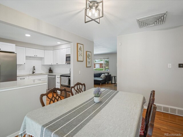 dining space with dark wood-style flooring, recessed lighting, and baseboards