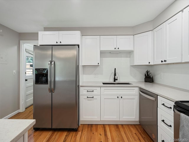 kitchen featuring appliances with stainless steel finishes, a sink, and light countertops