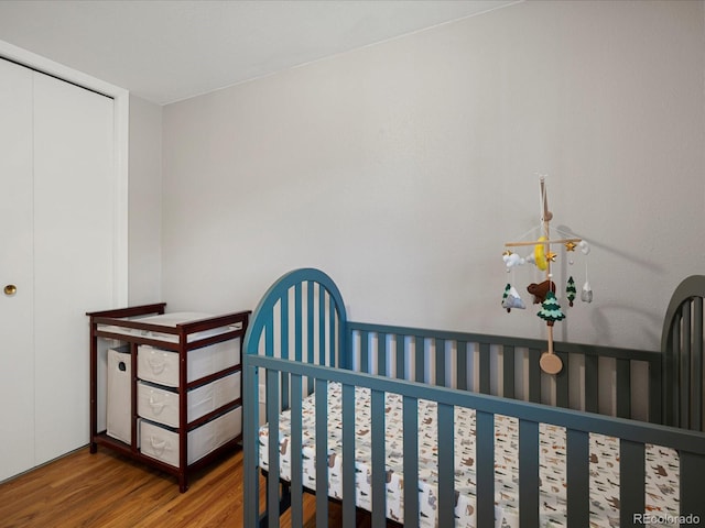 bedroom with wood finished floors and a closet