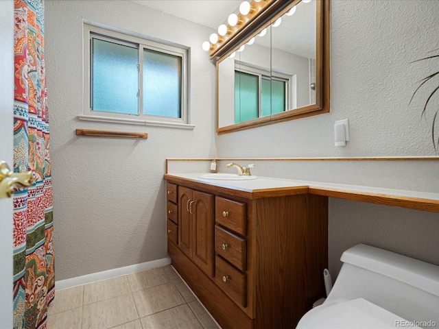 full bathroom featuring vanity, toilet, tile patterned flooring, and baseboards