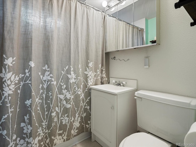 full bathroom featuring toilet, vanity, and a shower with curtain