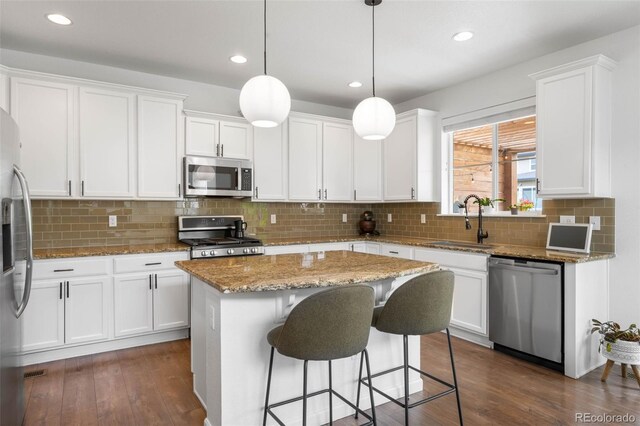 9567 Juniper Way, Arvada, CO 80007 - kitchen featuring stainless steel appliances, a sink, white cabinetry, dark wood-style flooring, and recessed lighting