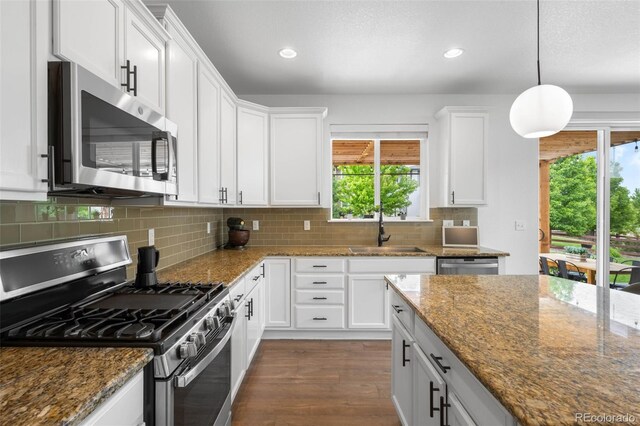 9567 Juniper Way, Arvada, CO 80007 - kitchen with appliances with stainless steel finishes, a sink, recessed lighting, dark wood-style flooring, and backsplash