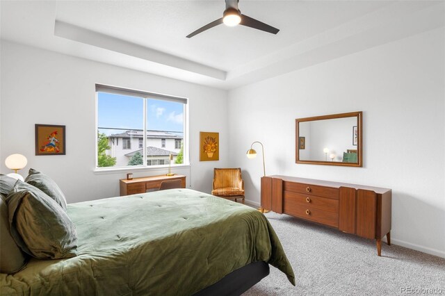 9567 Juniper Way, Arvada, CO 80007 - bedroom featuring light carpet, baseboards, a tray ceiling, and a ceiling fan