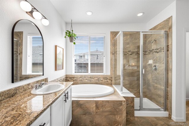 9567 Juniper Way, Arvada, CO 80007 - bathroom featuring vanity, a bath, a stall shower, healthy amount of natural light, and recessed lighting