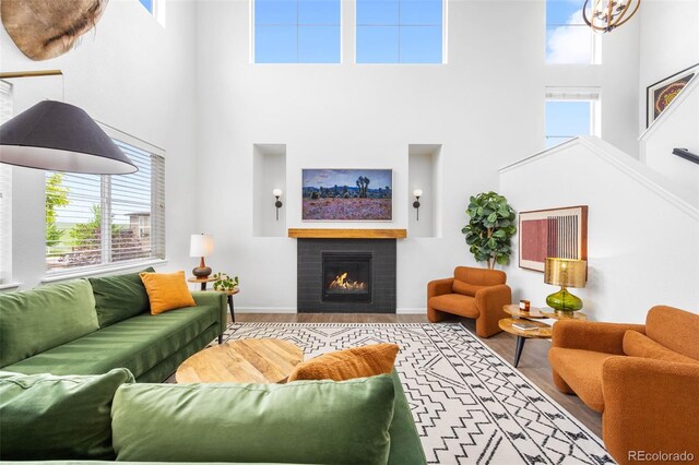 9567 Juniper Way, Arvada, CO 80007 - living room with a high ceiling, a fireplace, baseboards, and wood finished floors