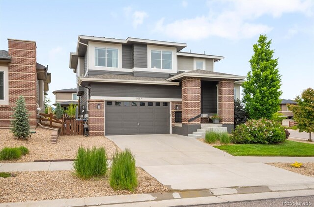 9567 Juniper Way, Arvada, CO 80007 - prairie-style house featuring a garage, concrete driveway, and brick siding