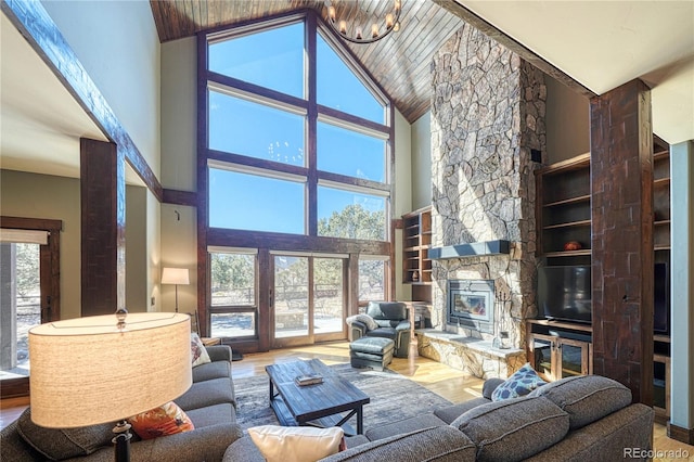 living room with plenty of natural light, wood finished floors, and a stone fireplace