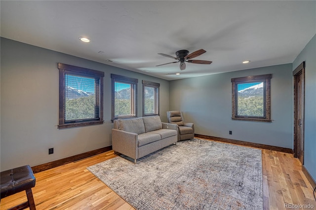 living room featuring ceiling fan, recessed lighting, light wood-style flooring, and baseboards