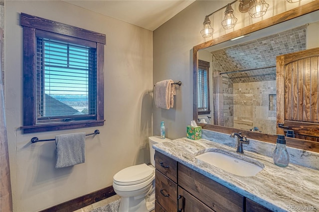 bathroom featuring baseboards, a tile shower, vanity, and toilet