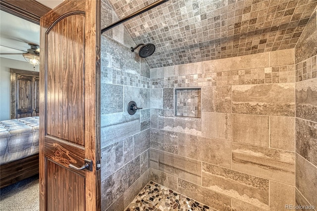 bathroom featuring a ceiling fan, tiled shower, and ensuite bath