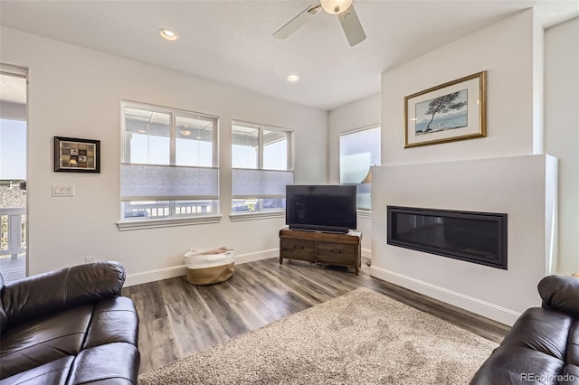 living area with healthy amount of natural light, wood finished floors, ceiling fan, and recessed lighting