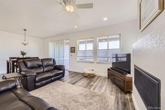 living room featuring wood finished floors, ceiling fan, recessed lighting, and baseboards