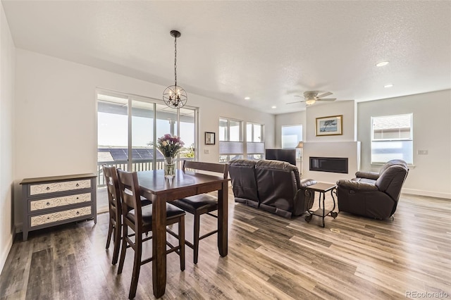 dining space featuring wood finished floors, ceiling fan, recessed lighting, baseboards, and a chandelier
