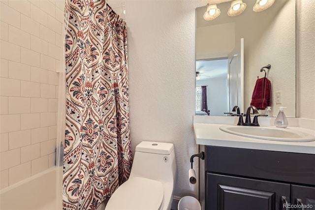 bathroom with toilet, vanity, a textured wall, and shower / bath combo