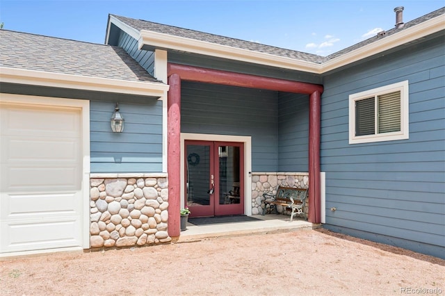 29004 Amerind Springs Trl, Pine, CO 80470 - property entrance featuring stone siding, a shingled roof, french doors, and an attached garage