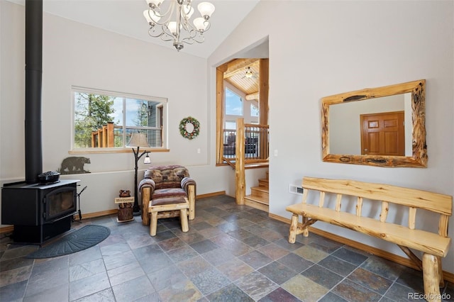 29004 Amerind Springs Trl, Pine, CO 80470 - sitting room featuring vaulted ceiling, stone tile flooring, a wood stove, stairway, and a chandelier