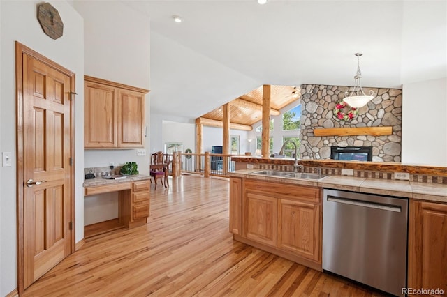 29004 Amerind Springs Trl, Pine, CO 80470 - kitchen with stainless steel dishwasher, light wood-style flooring, a stone fireplace, decorative light fixtures, and high vaulted ceiling