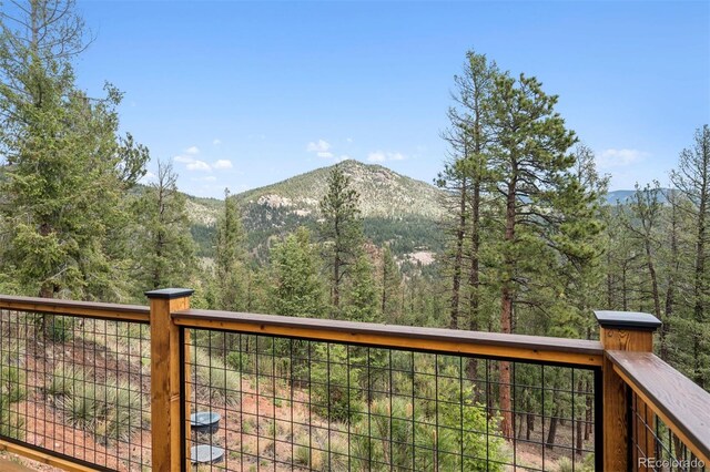 29004 Amerind Springs Trl, Pine, CO 80470 - wooden deck with a mountain view and a forest view