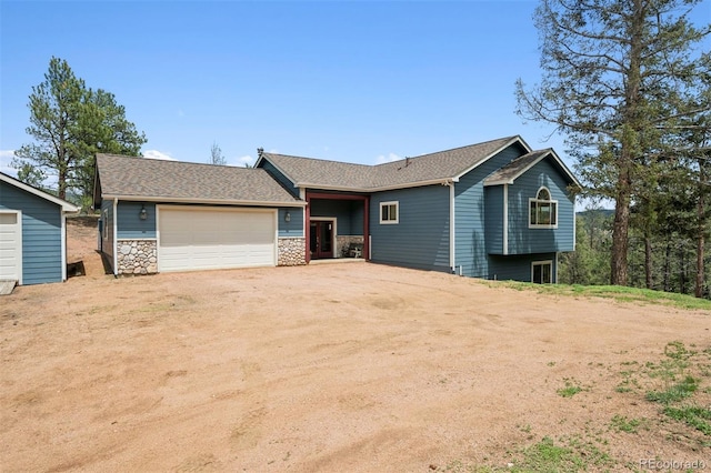 29004 Amerind Springs Trl, Pine, CO 80470 - view of front of property featuring a garage, stone siding, and roof with shingles