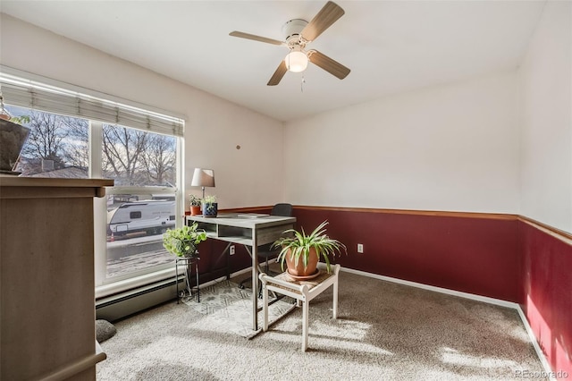 office space featuring baseboard heating, ceiling fan, and carpet