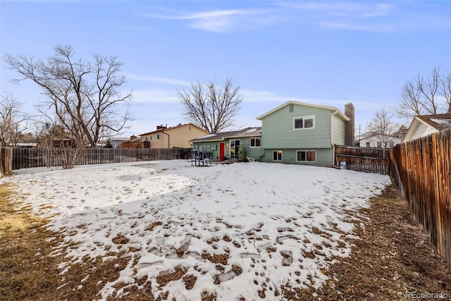 view of snow covered rear of property