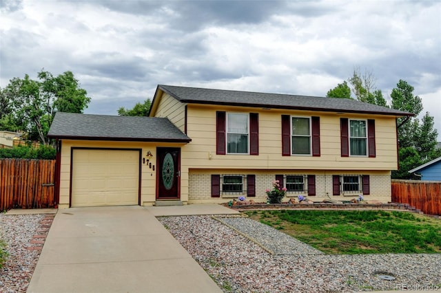 9766 Fillmore St, Thornton, CO 80229 - tri-level home with concrete driveway, a garage, brick siding, and roof with shingles