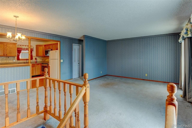 9766 Fillmore St, Thornton, CO 80229 - spare room featuring light carpet, a textured ceiling, wallpapered walls, and a chandelier